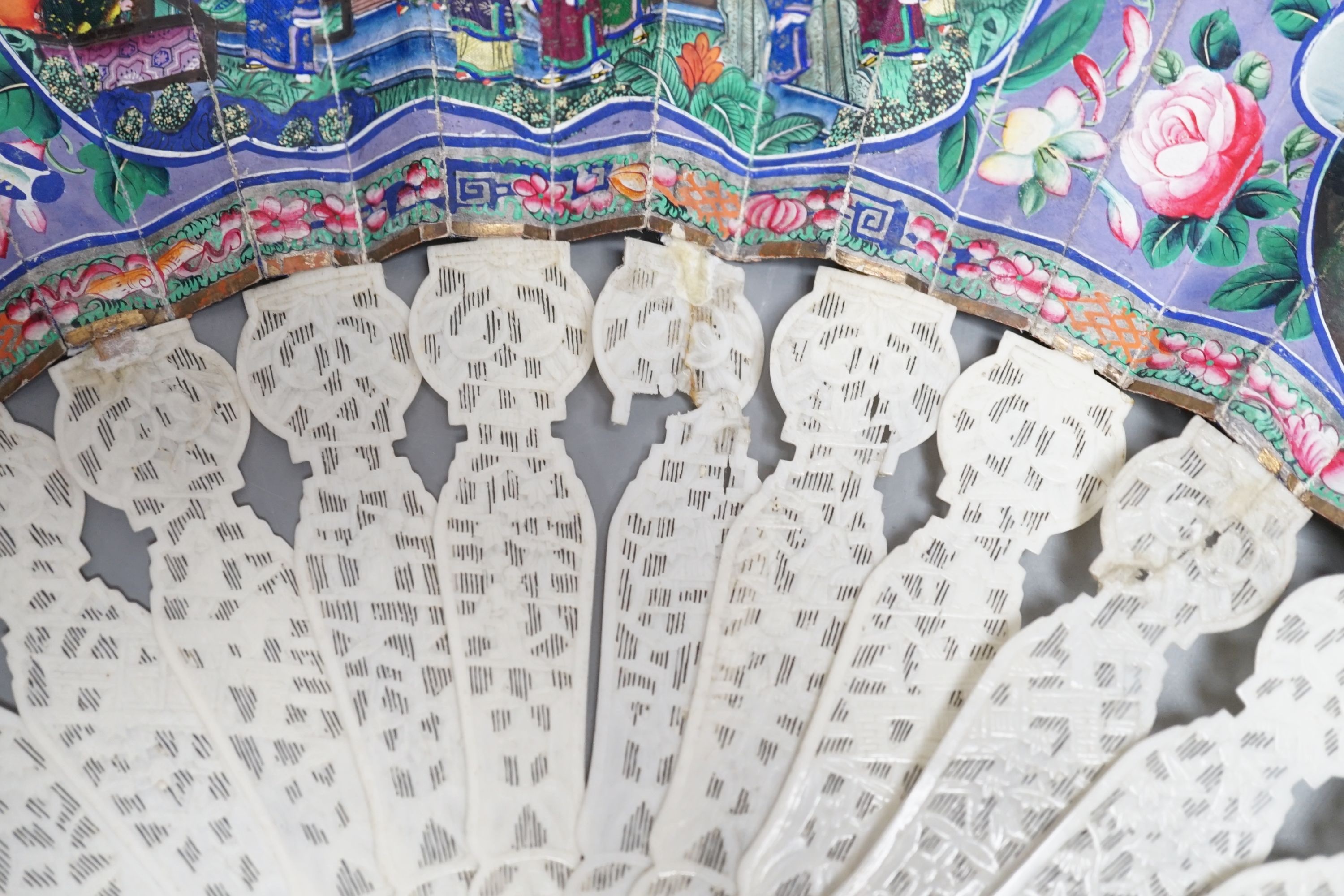 A 19th century Chinese export pierced ivory and painted paper leaf fan, in box. Fan 28cm long